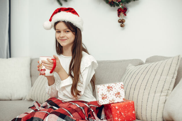 圣诞老人穿白色毛衣的孩子坐在圣诞树旁的女儿传统金发小
