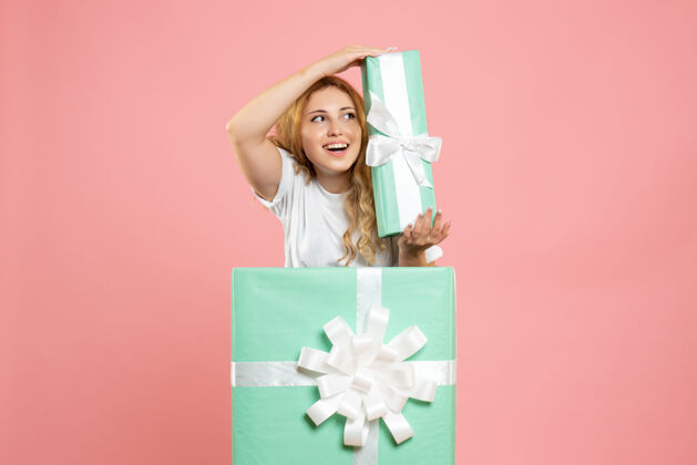 颜色正面图年轻女性站在盒子里拿着礼物女士女性里面