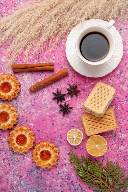 顶端顶视图一杯茶 配上饼干和华夫饼 粉色桌面饼干饼干甜甜的馅饼颜色茶脸华夫饼干
