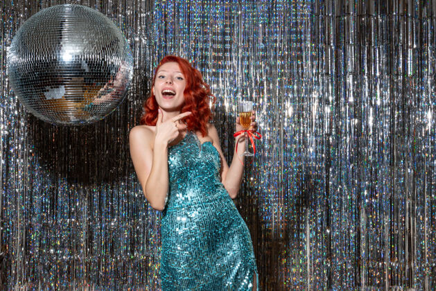 迪斯科年轻女性在派对上庆祝新年 迪斯科舞会挂在明亮的窗帘上年新年女士
