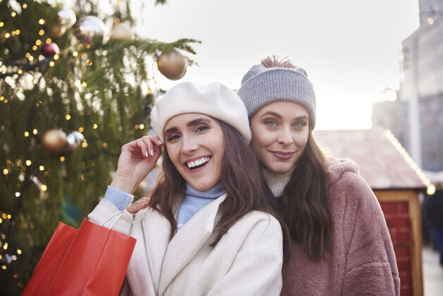 圣诞装饰圣诞集市上两个穿着暖和衣服的女人的画像旅游购物公平
