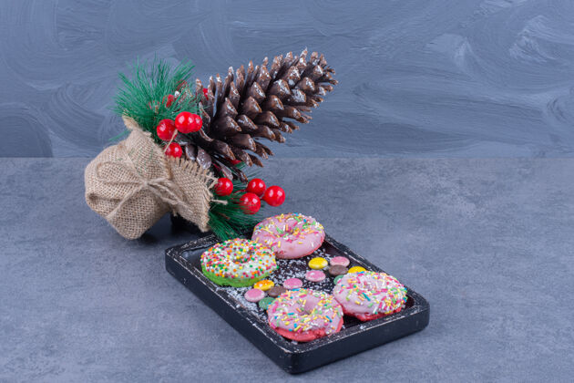 好吃一块黑板上装满了甜甜圈和果冻糖圣诞松果木板吃