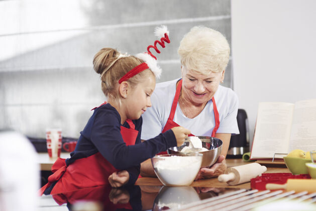 准备饭菜奶奶教她的孙子怎么做蛋糕协助合作帮助