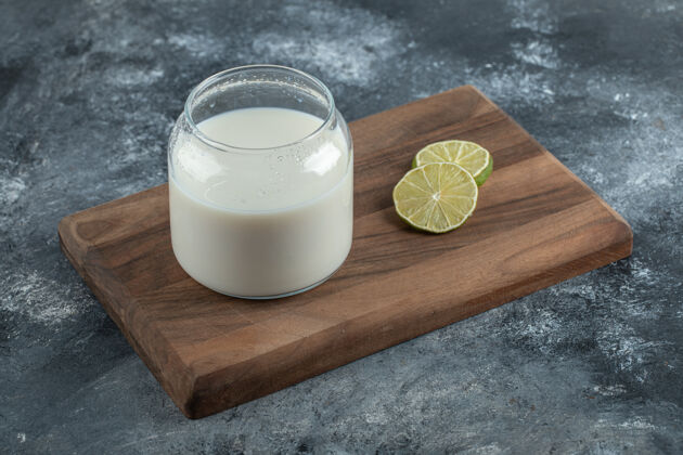 玻璃一杯鲜奶和柠檬片放在木板上产品饮料乳制品