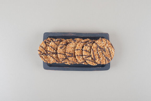 美味把一捆饼干放在大理石背景的木盘上甜点商品曲奇