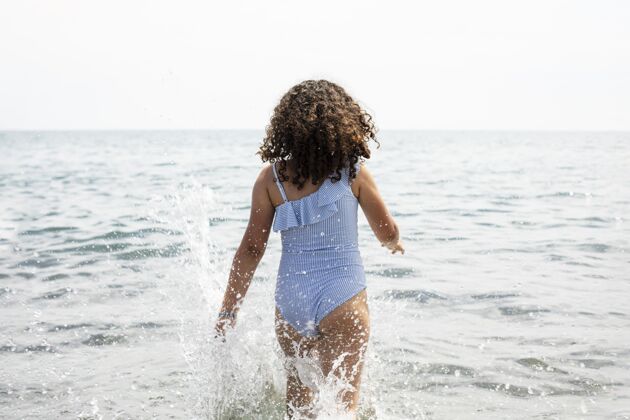 海边中枪女孩在水里玩中镜头海滩户外