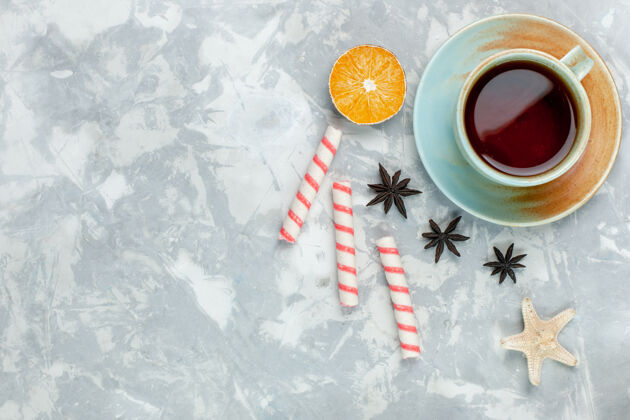 滑雪顶视图一杯茶 柠檬和糖果背景为浅白色糖果水果甜茶季节生的山