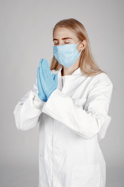 医生戴着医用面罩的医生冠状病毒隔离在白墙上成人妇女外科医生