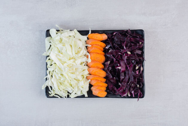 胡萝卜切碎的胡萝卜 红白的卷心菜放在黑盘子里高质量的照片切碎植物生的
