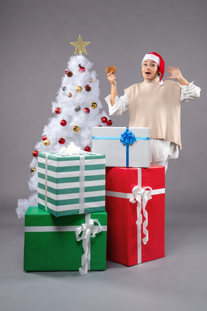 圣诞拿着饼干的年轻女人圣诞树包灰色