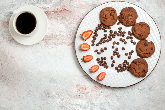 生的俯瞰美味的巧克力饼干与巧克力片咖啡和草莓白色背景饼干糖甜蛋糕饼干背景棉花顶部