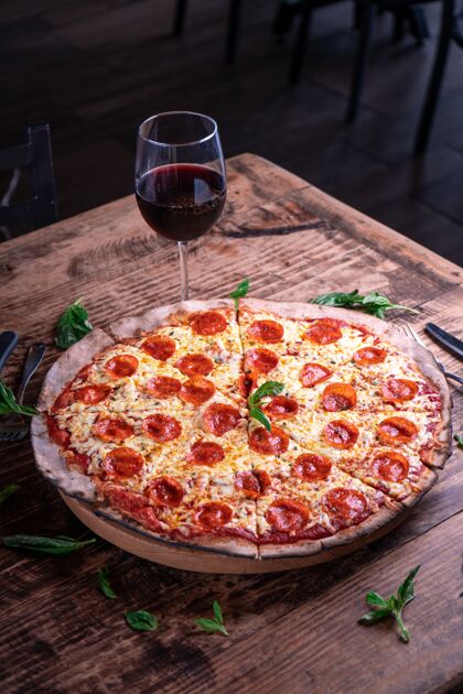 美味垂直拍摄美味的芝士意大利香肠比萨和一杯葡萄酒放在木桌上番茄美味小吃
