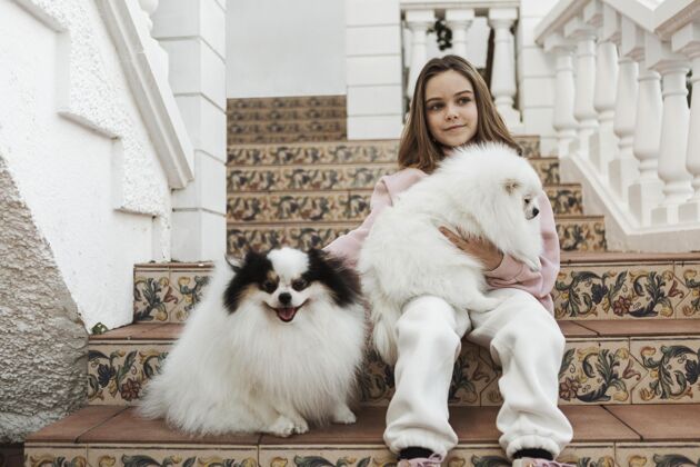 感情女孩和可爱的白色小狗坐在楼梯上孩子朋友小狗
