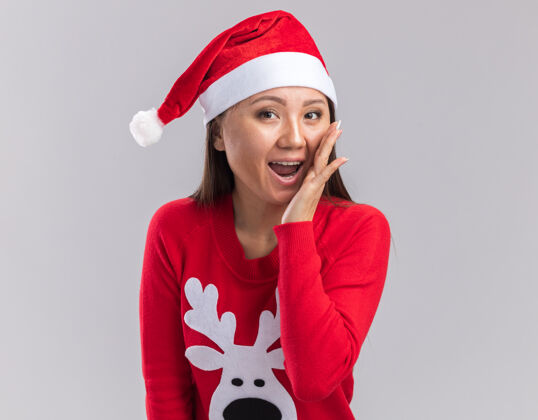 毛衣快乐的年轻亚洲女孩戴着圣诞帽 穿着毛衣 在白色背景上呼唤着一个孤独的人快乐圣诞节亚洲人