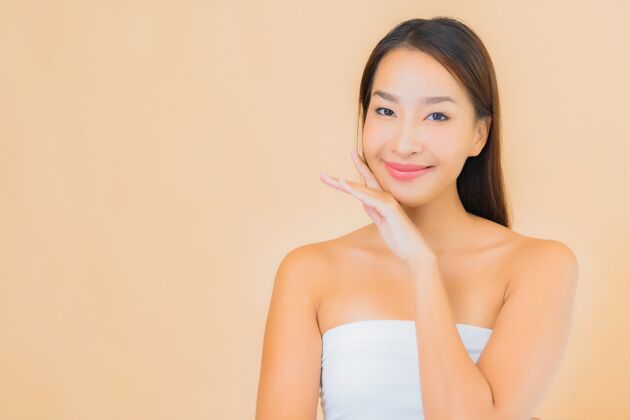 身体肖像美丽的年轻亚洲女子在温泉与自然化妆米色皮肤护理干净美国人
