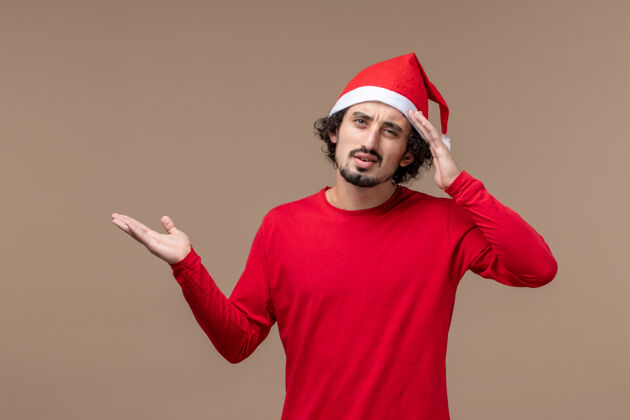 帽子前视图年轻人与思考表达对棕色背景节日情感圣诞节人微笑前面