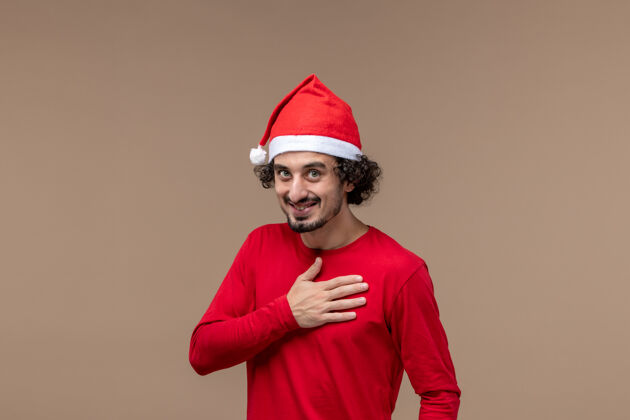 男人正面图红色的男性鞠躬和微笑的棕色背景节日情感圣诞节圣诞节微笑浴帽
