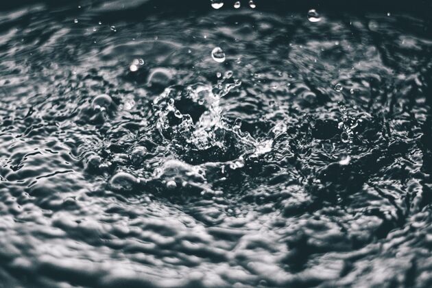 玻璃高角度特写镜头的飞溅的水在水面上的湖泊河流气泡雨滴