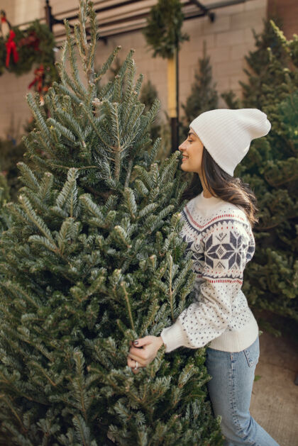 商店优雅的女孩买了一棵圣诞树市场庆祝传统