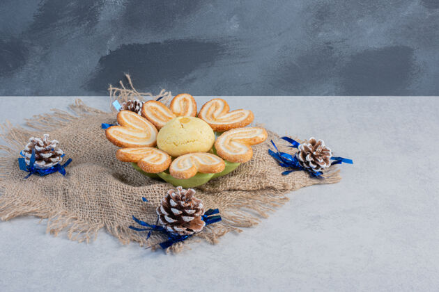 甜的饼干拼盘在一块布中间松果在大理石表面美味曲奇甜点