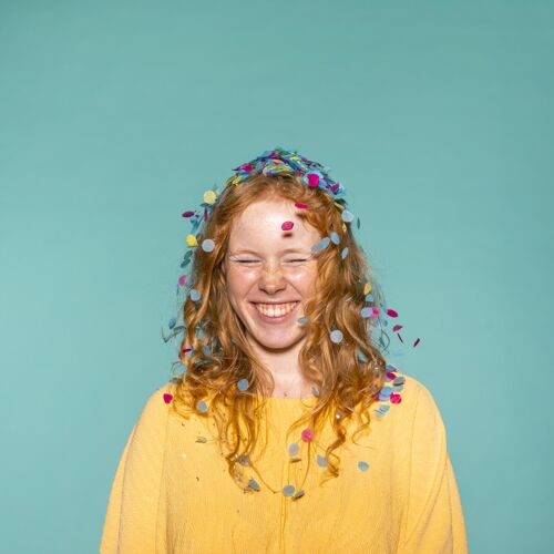 周年纪念年轻的红发女人头发上夹着五彩纸屑在聚会喜庆美丽庆祝