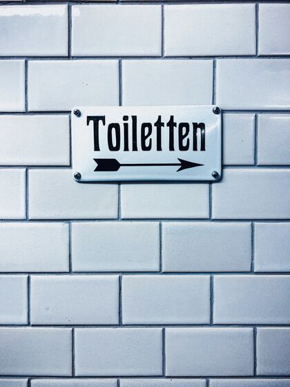 护理特写垂直拍摄的厕所标志与德国文字德国禁止砖块