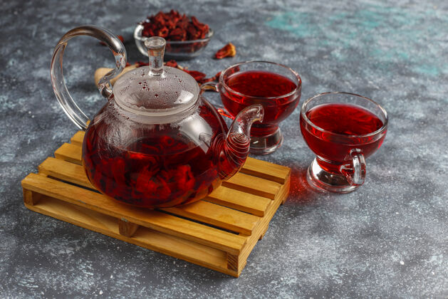 杯热木槿茶在一个玻璃杯子和玻璃茶壶粉色肉桂玫瑰