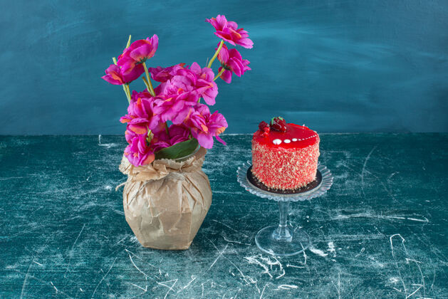 蛋糕蛋糕放在台座上 旁边是蓝色的花瓶美味鲜花糕点