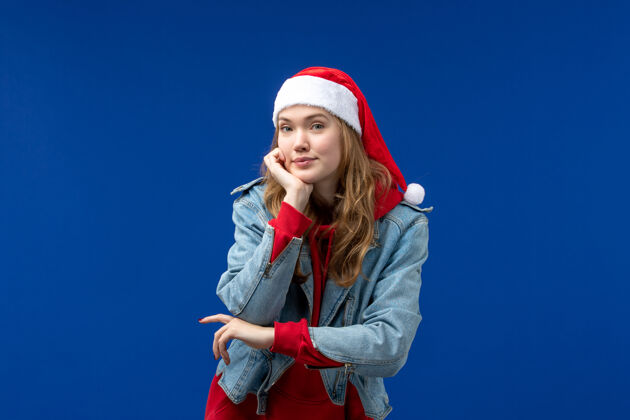 男性正面图：年轻女性在蓝色背景上摆姿势 感慨圣诞假期背景正面肖像
