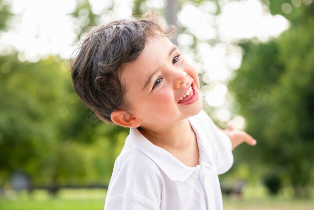 公园快乐有趣可爱的男孩跳舞 欢笑 在夏季公园玩得开心 微笑着看着别处特写镜头童年的概念有头发孩子