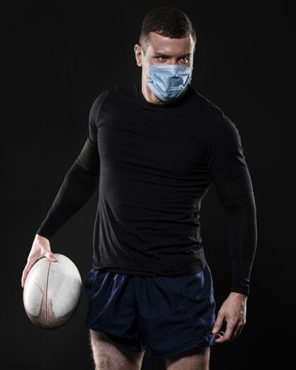 男子男橄榄球运动员带着医用面罩拿着球锦标赛球员男子