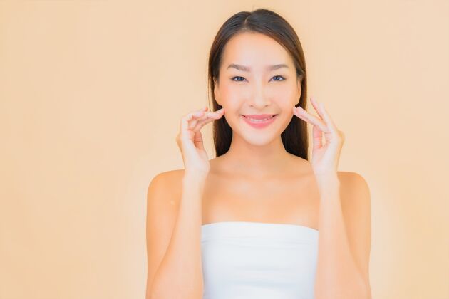 干净肖像美丽的年轻亚洲女子在温泉与自然化妆米色快乐皮肤护理肖像