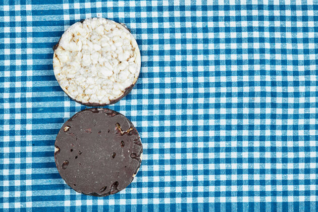 糖蓝色桌布上的巧克力饼干奶油饼干特写
