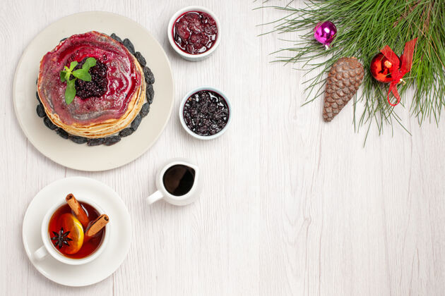 清淡俯瞰美味的果冻煎饼和葡萄干果冻和茶浅白色午餐早餐杯子
