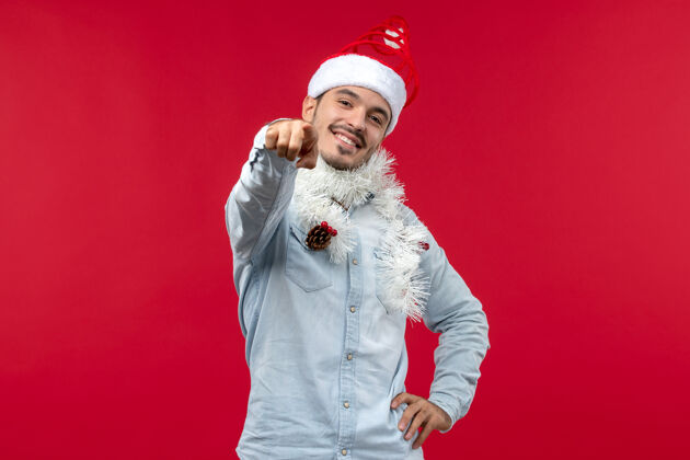 节日圣诞气氛中的年轻人在红墙上微笑的正面图时尚帅哥男人