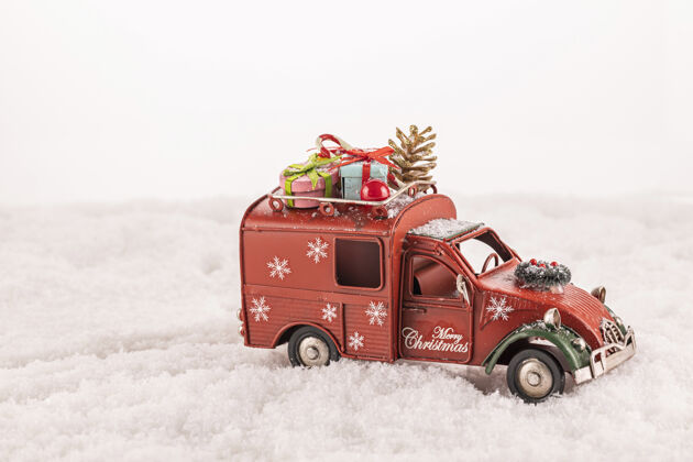 乐趣特写的玩具车与圣诞饰品上的人造雪对白色的背景树枝快乐盒子