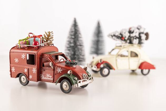 小小玩具汽车的特写镜头放在桌子上 背景是小圣诞树气氛灯背景