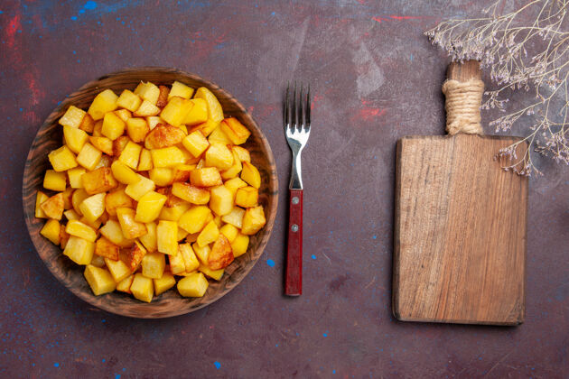 小吃俯视图在黑暗的桌子上的盘子里切熟的土豆饮食烹饪健康