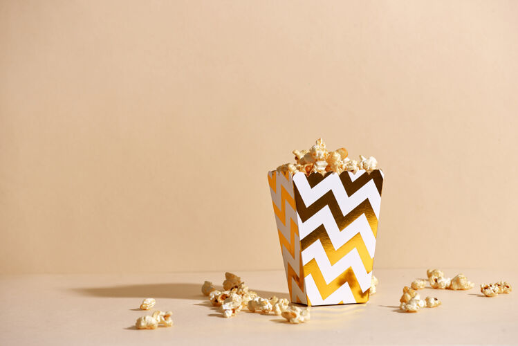 圣诞节咸鲜硬皮自制爆米花在金色纸杯里的时尚表面庆祝节日活动