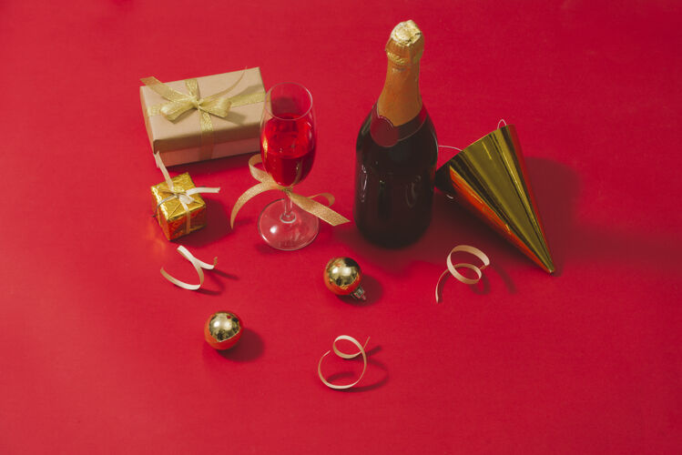 装饰品红桌子上的香槟和圣诞装饰品舞会圣诞节季节