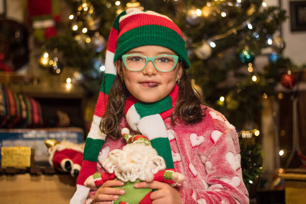 快乐可爱的女孩微笑着拿着她的圣诞老人玩具年轻微笑礼物