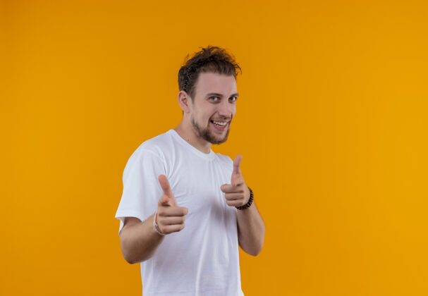 T恤微笑的年轻人穿着白色t恤 在孤立的橙色背景上展示你的手势穿着白色橙色