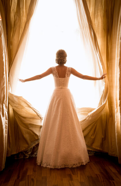 长美丽新娘在酒店房间橱窗前摆姿势的色调照片人女士新娘