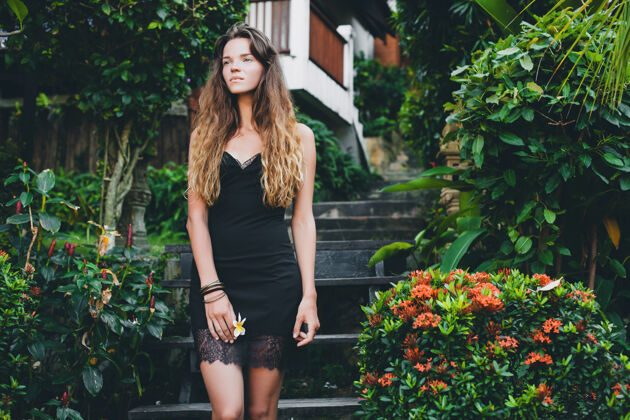 温柔热带花园里年轻漂亮性感的女人 在泰国度暑假 苗条瘦削的棕褐色身材 带蕾丝的小黑裙 自然的造型 感性的 放松的 女士年轻魅力