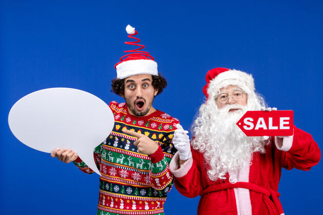 折扣前视图圣诞老人与年轻男子手持白色标志和销售文字颜色销售销售