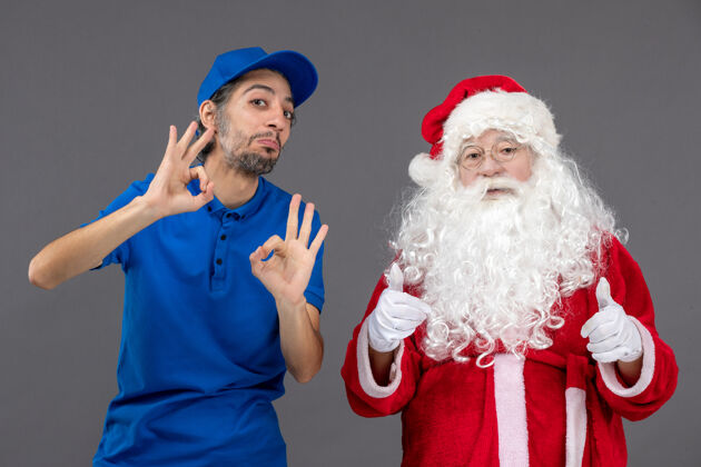 正面灰色墙上的圣诞老人和男信使的正面图节日圣诞快乐