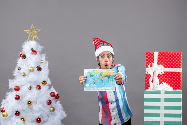 圣诞帽前视图惊讶的男子与螺旋弹簧圣诞帽显示世界地图人圣诞老人礼品盒