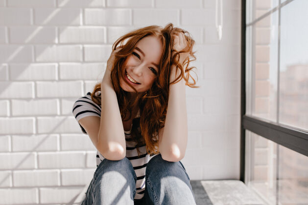 生姜迷人的年轻白种人模特在家里摆姿势漂亮的姜汁女孩玩她的头发和笑情感红发女人