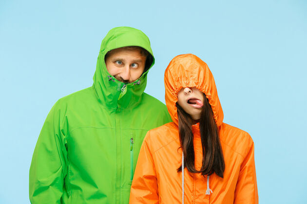 成人这对年轻夫妇穿着蓝色的秋夹克在摄影棚摆姿势天气时尚男性