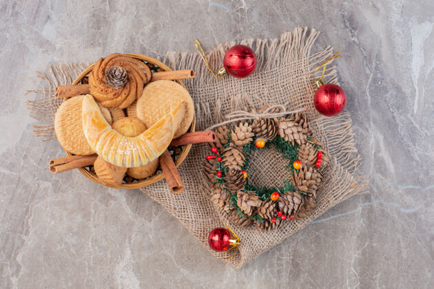 糖圣诞花圈 圣诞树装饰和一个放在大理石上的糕点篮美味美味顶部视图